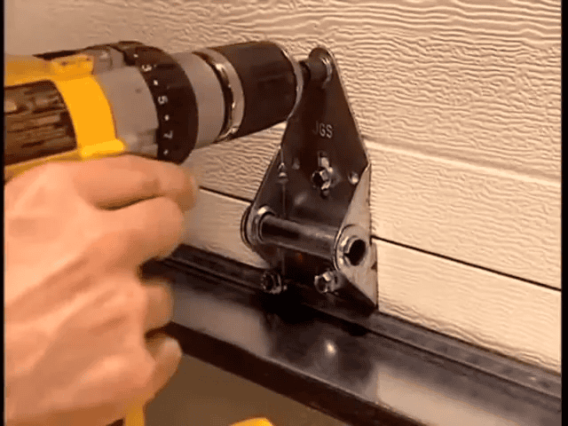 An In-Depth Look at How Garage Doors Are Made 8 Technicians installing hinges and springs during on-site installation